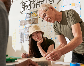 A man and woman doing crafts at a table.