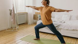 Older person doing yoga at home on yoga mat