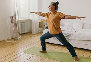 Older person doing yoga at home on yoga mat