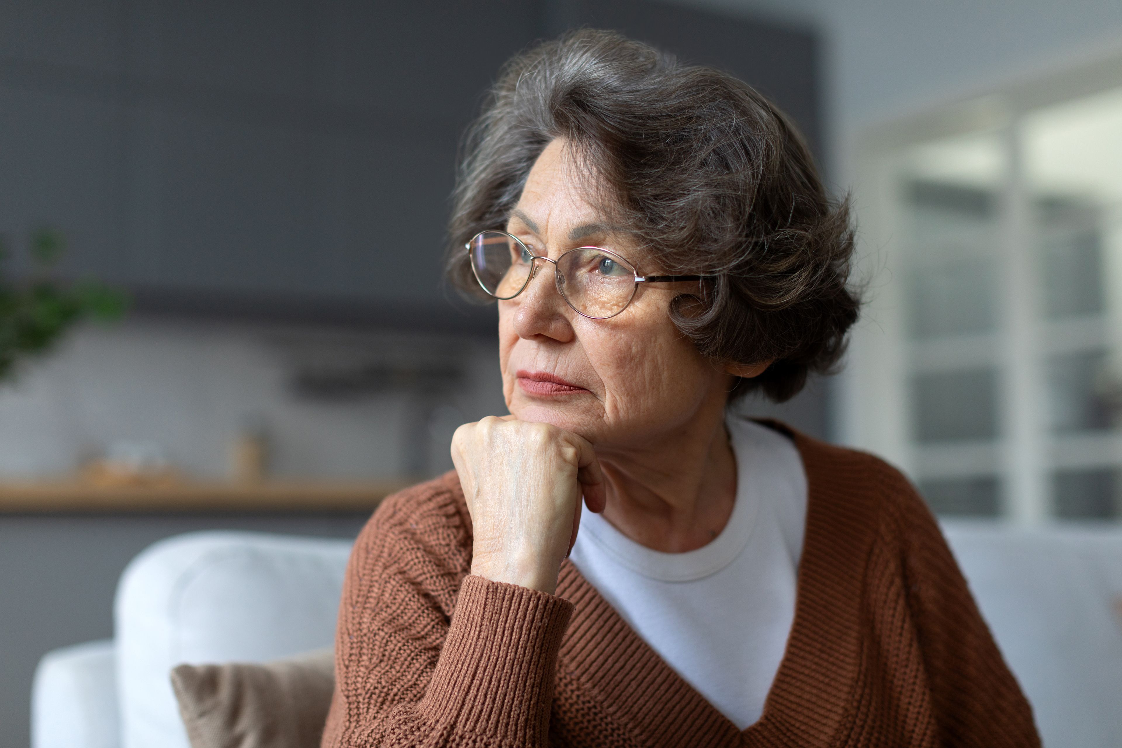 Pensive looking older person sitting at home