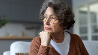 Pensive looking older person sitting at home