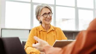 Older woman talking to co-worker.