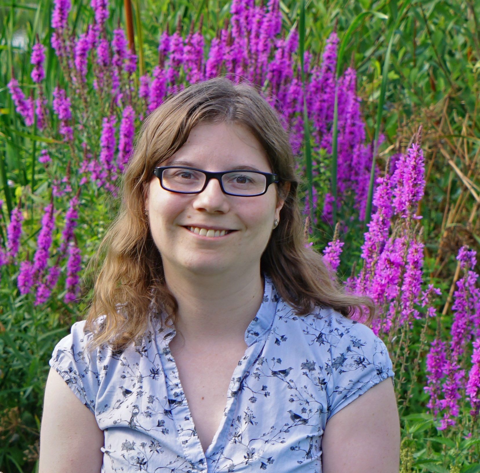 A headshot of Dr Coleman standing in a field of lavendar.