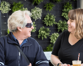 A Guide Dogs worker and Client having coffee.