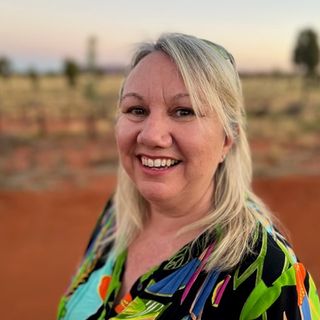 Nadine McArthur smiling at the camera standing in a desert environment
