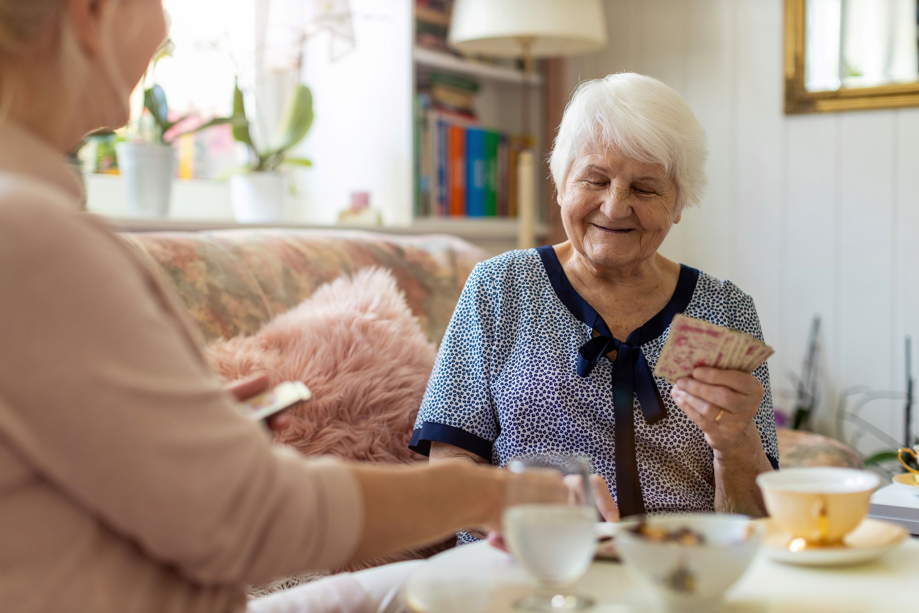 Two older people playing cards at home