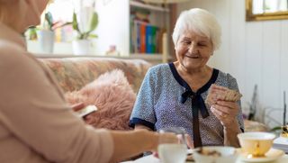Two older people playing cards at home