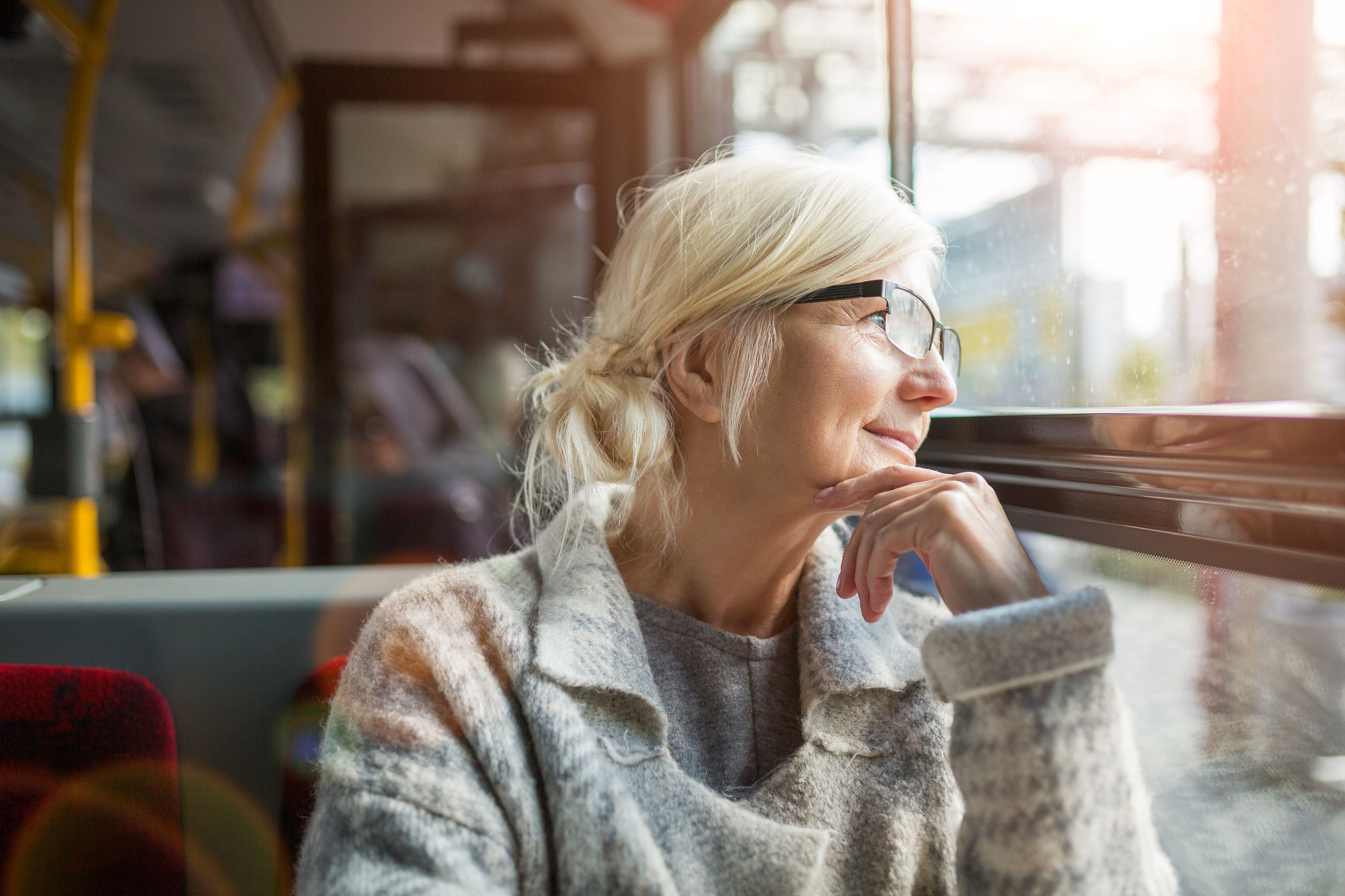 Older person looking out bus window