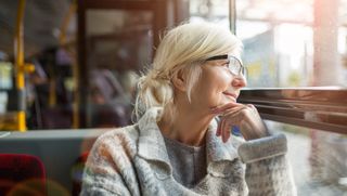 Older person looking out bus window