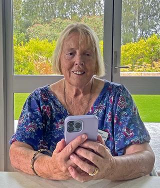 SeeWay client Angela using her phone sitting down at home