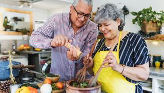 Older couple cooking together in kitchen