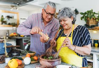 Older couple cooking together in kitchen