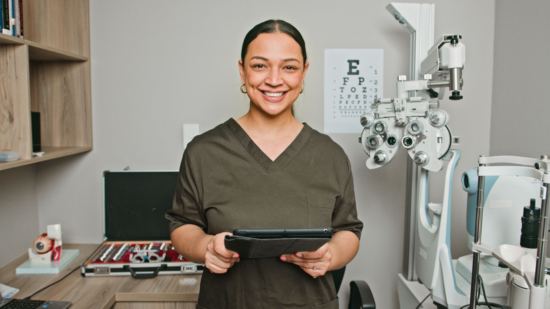 Smiling optometrist holding an iPad in her office
