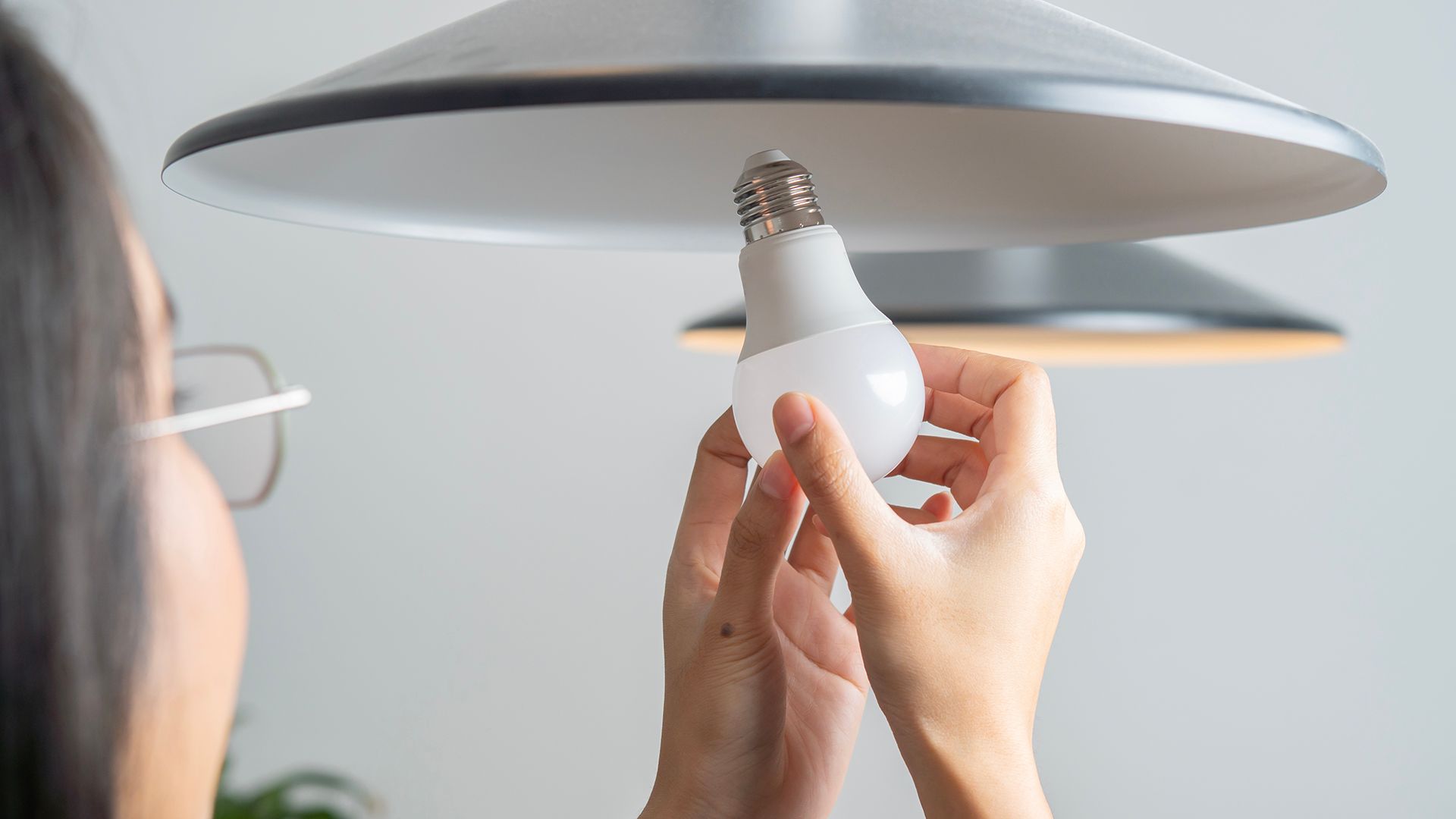 Woman changing a smart light bulb