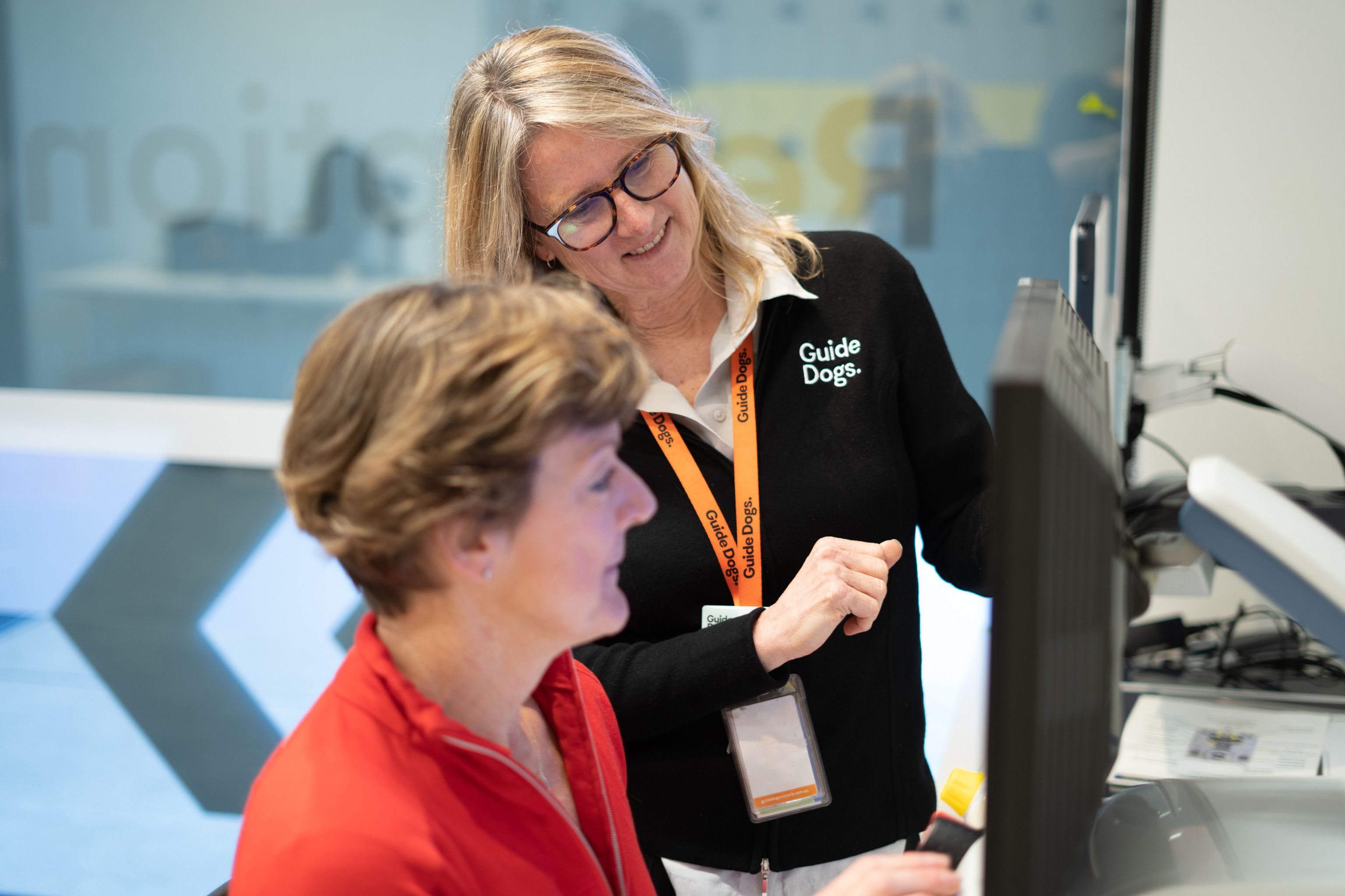 A Guide Dogs employee helping a client use assistive technology
