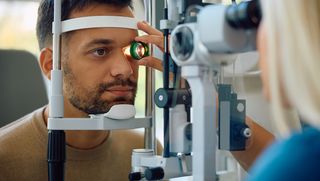 Younger man having his eyes tested by a medical professional