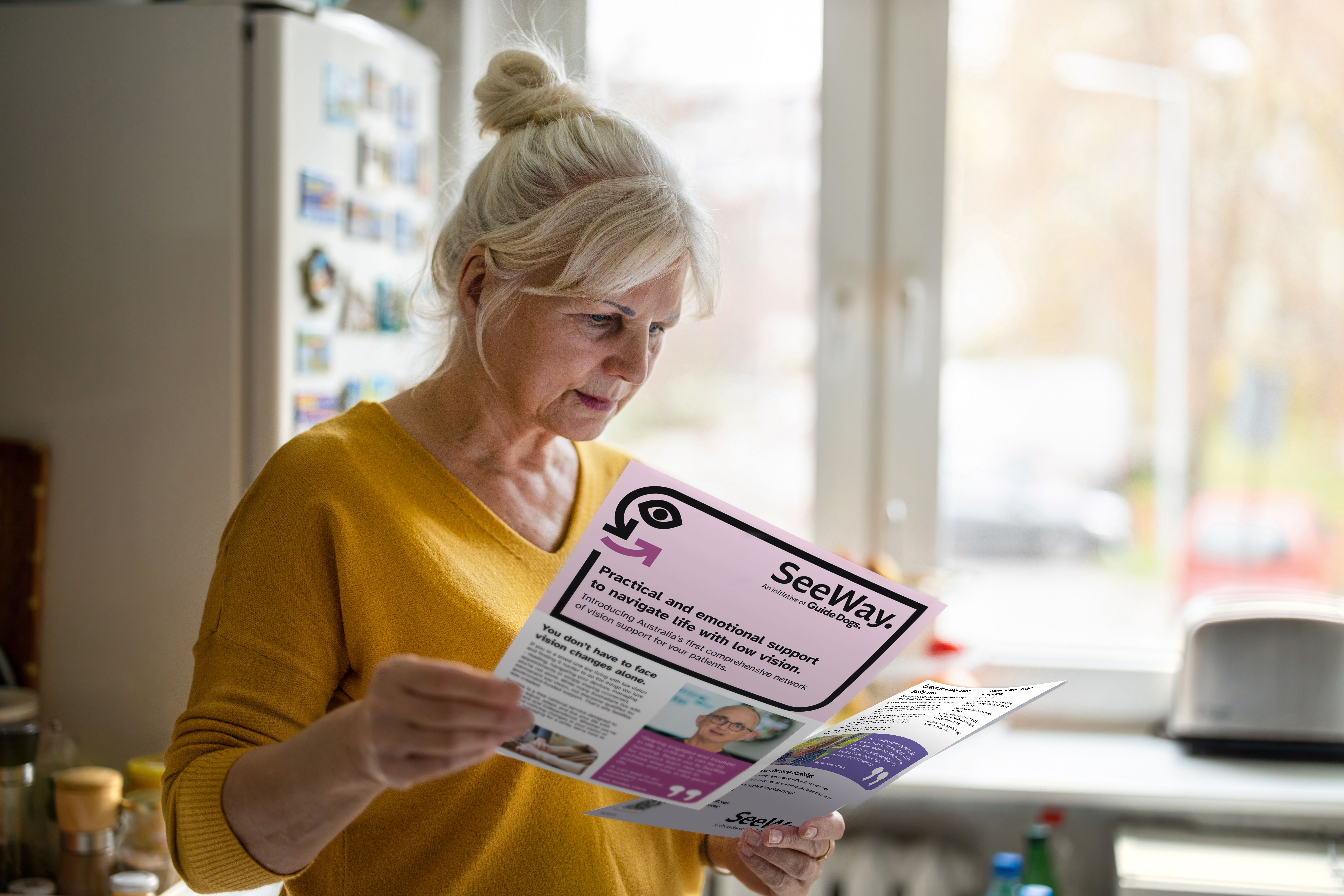 A woman reading two different SeeWay flyers. 