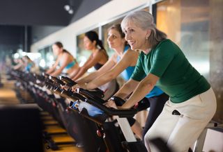 Older woman in gym taking cycling class