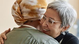 Close-up of two people hugging and smiling