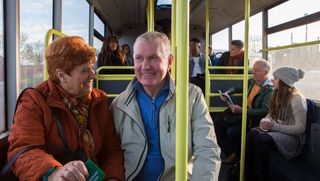 Happy older couple sitting together on a bus