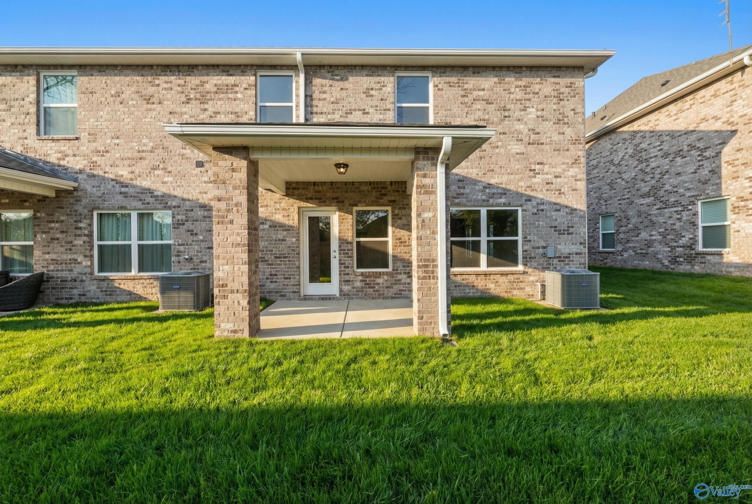Covered brick patio with French doors and lush green lawn in Davidson Homes The Camden, Pavilion, Huntsville, Alabama