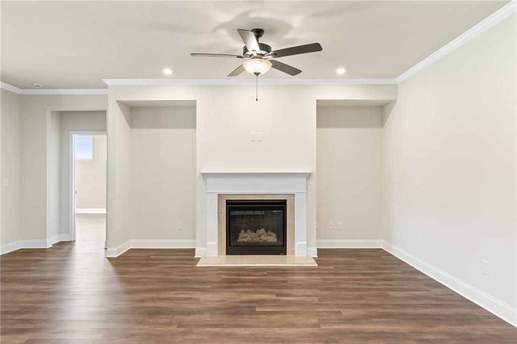 Cozy family room with gas fireplace, ceiling fan, hardwood floors in Davidson Homes The Harrison H, Winder, GA