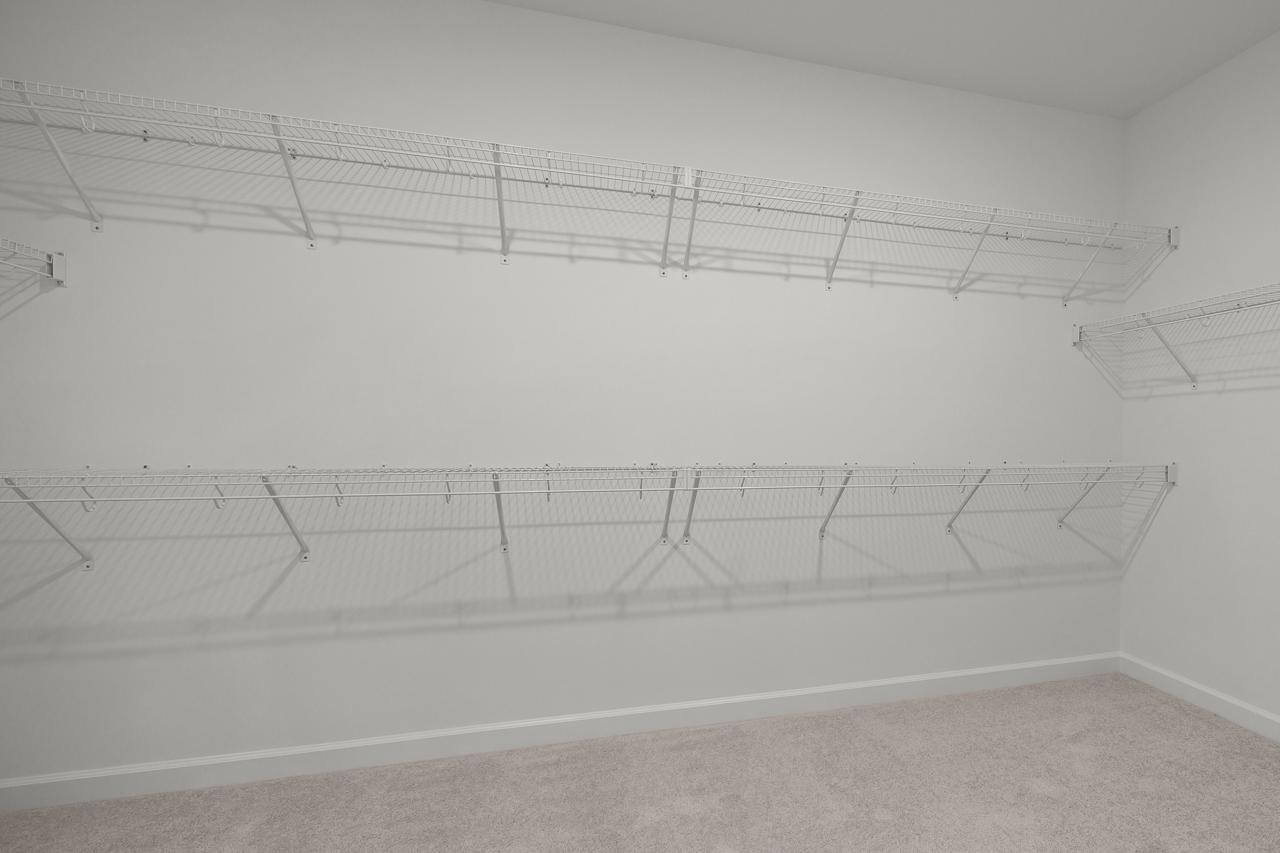 Spacious walk-in closet with wire shelving in the master suite of The Birch II D home design by Davidson Homes.