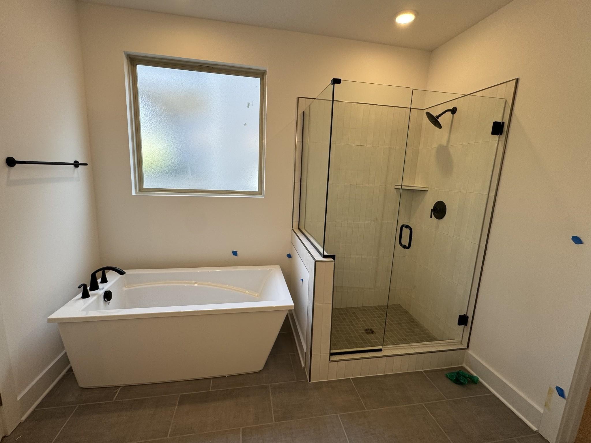 Modern master bathroom featuring freestanding tub and glass-enclosed shower in Davidson Homes Ridgeport C, Gallatin, TN