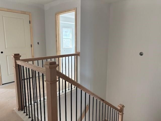Elegant wooden staircase with black metal balusters in 2-story 5-bedroom The Hickory B home by Davidson Homes, Winder, Georgia