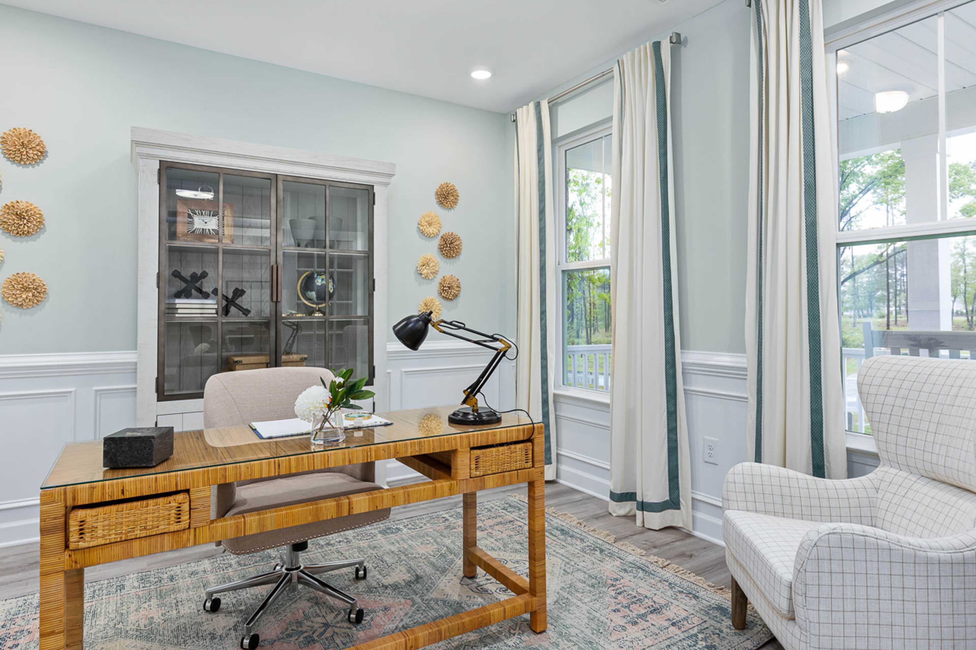 Cozy home office at Weatherford East in Angier NC with wooden desk, blue walls, woven decor and large windows