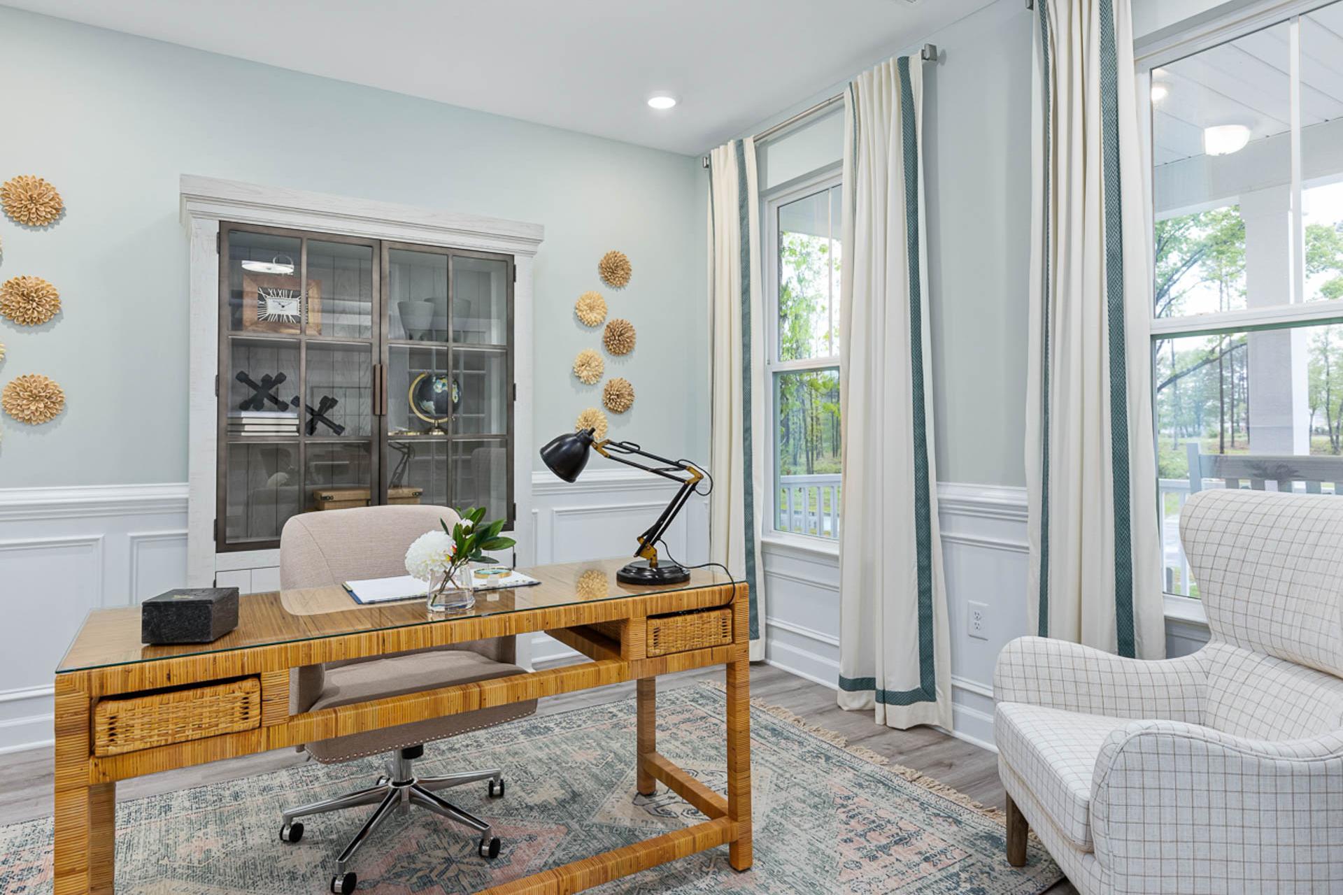 Cozy home office at Weatherford East in Angier NC with wooden desk, blue walls, woven decor and large windows