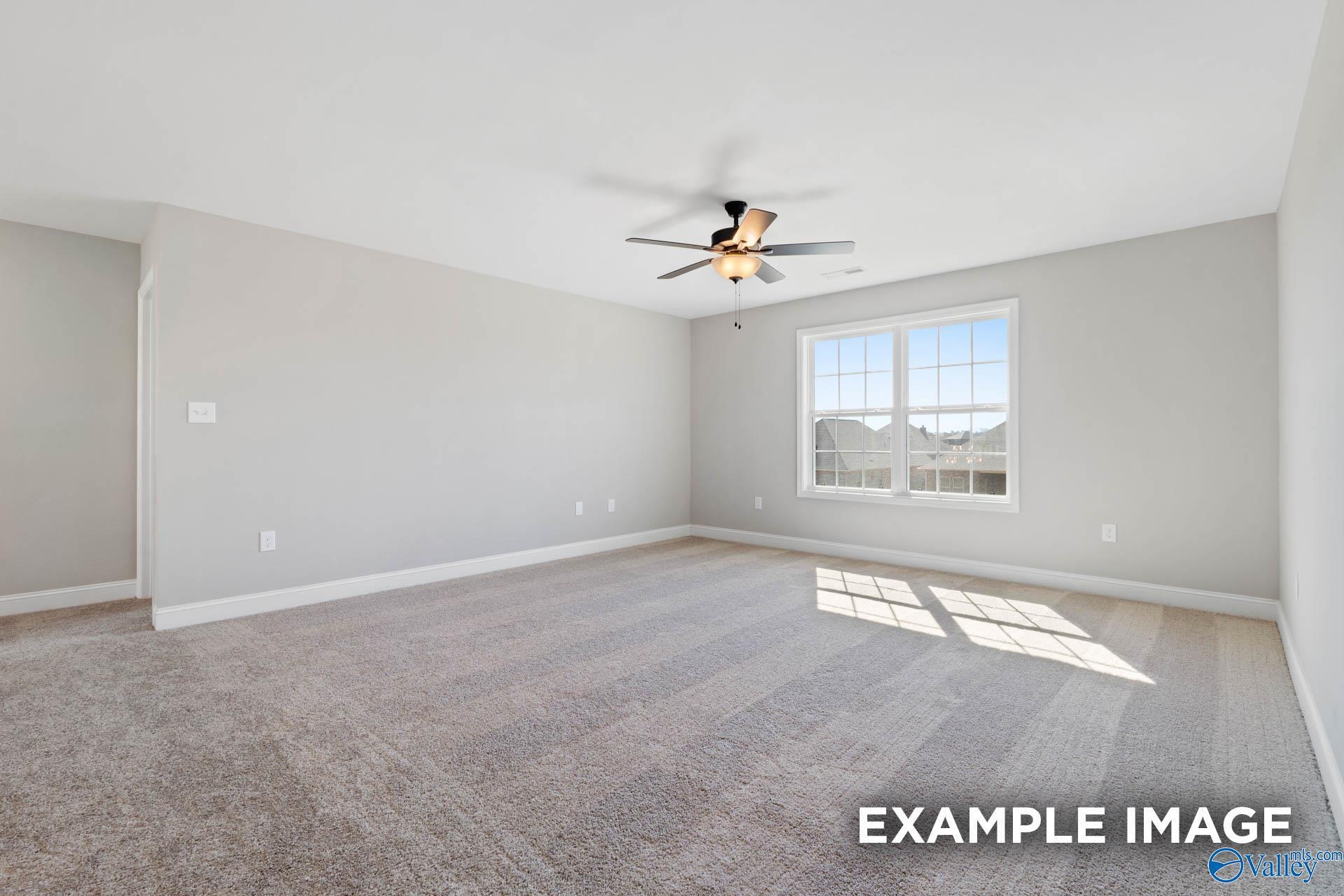 Spacious, carpeted bedroom with ceiling fan in The Madison D floor plan by Davidson Homes in Evergreen Mill, Madison, AL.