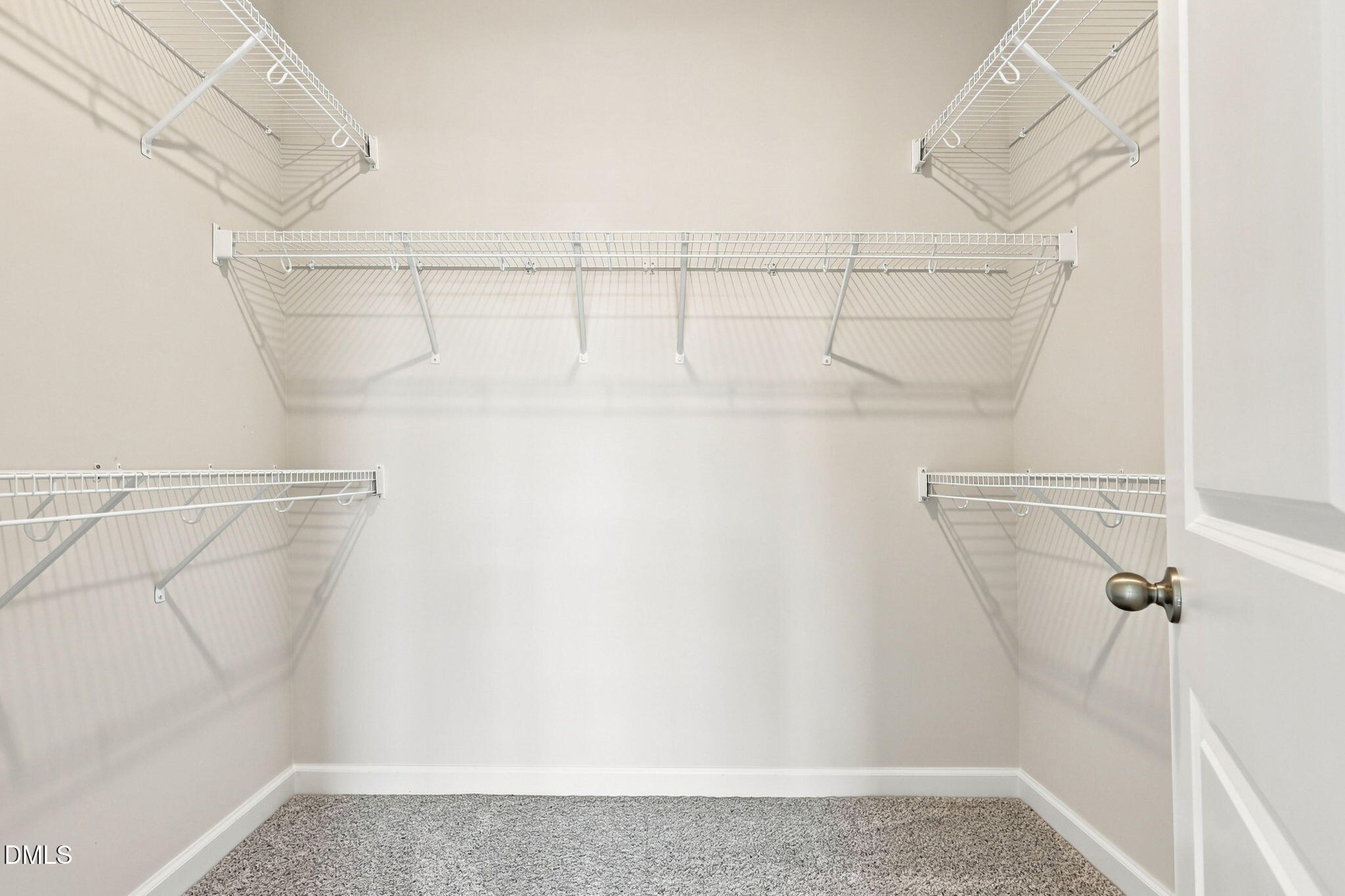 Walk-in closet with white wire shelving in The Magnolia B floor plan at Retreat at North Main in Lillington, NC.