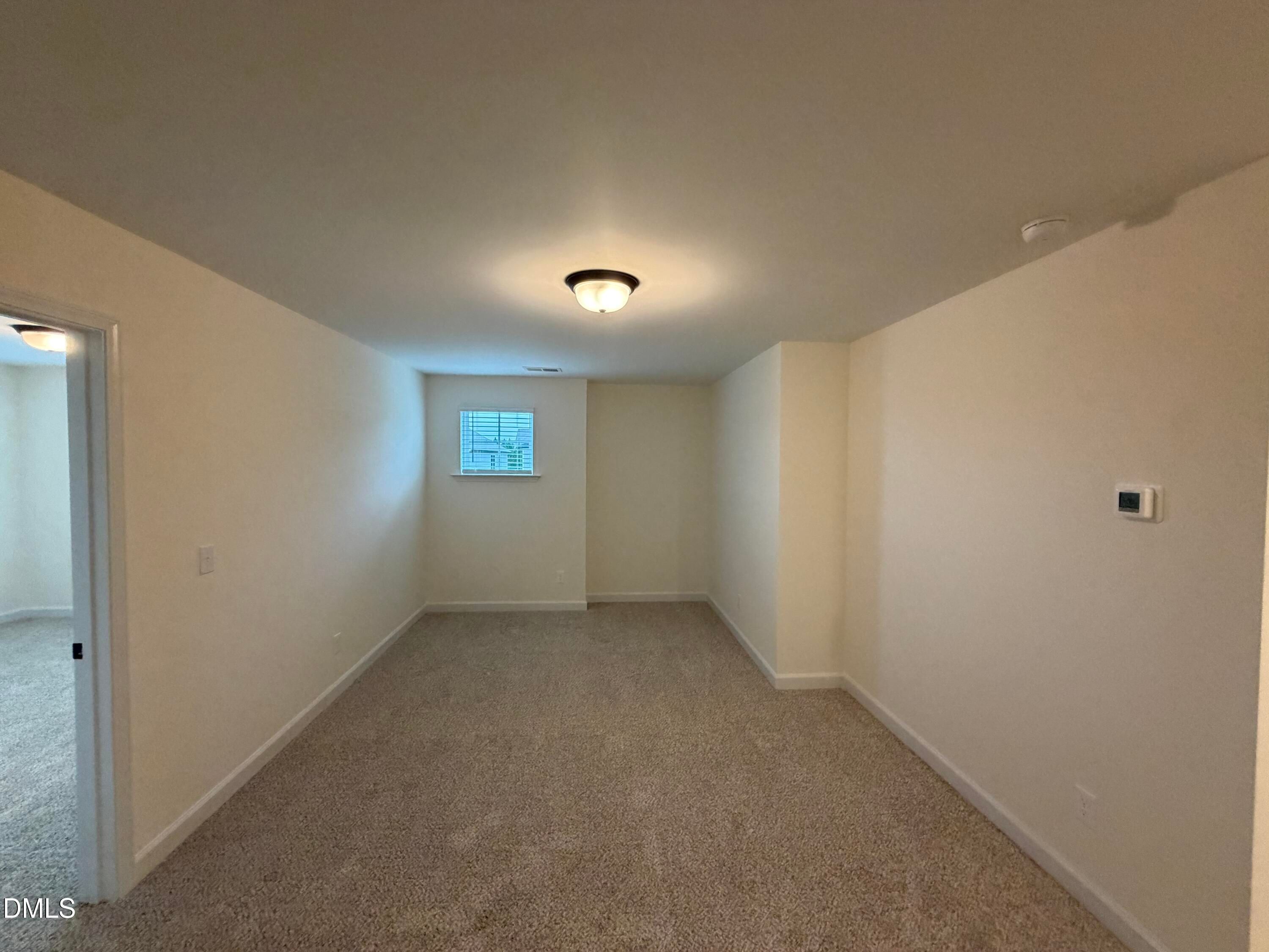 Spacious carpeted bedroom with ceiling light and window in Davidson Homes The Ashport M plan, Wendell Ridge, North Carolina