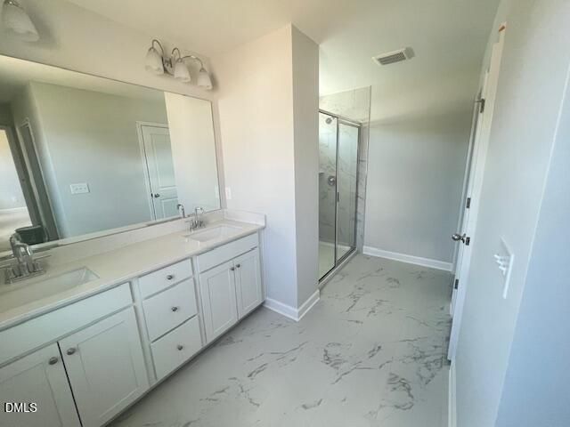 Modern master bathroom with double white vanity, marble countertop, frameless glass shower in The Adalynn A, Lillington, NC