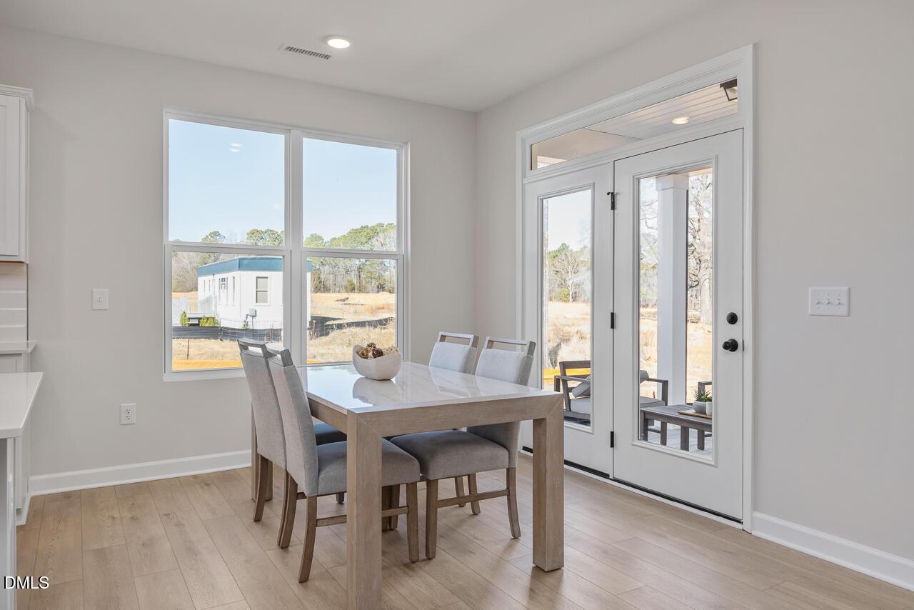 Bright dining area with glass doors leading to a patio in The Ash C floor plan at Woodland Crossing, Zebulon, NC.