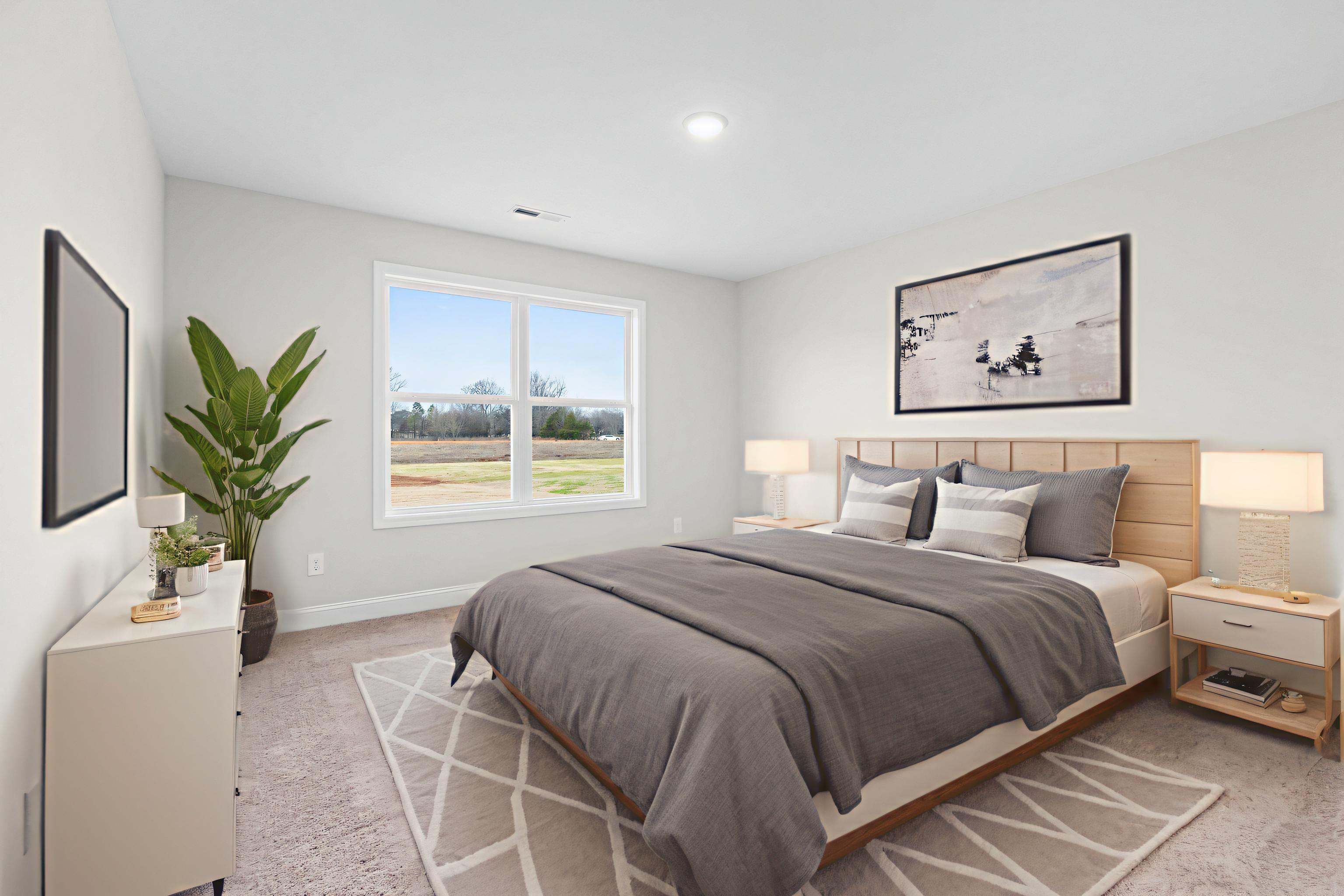 Serene bedroom at Chapel Hill in Athens Alabama with gray walls queen bed large window rural view potted plant and neutral decor