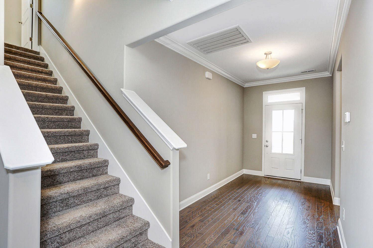 Spacious entry foyer and carpeted staircase in The Montgomery home by Davidson Homes, hardwood floors, neutral gray walls