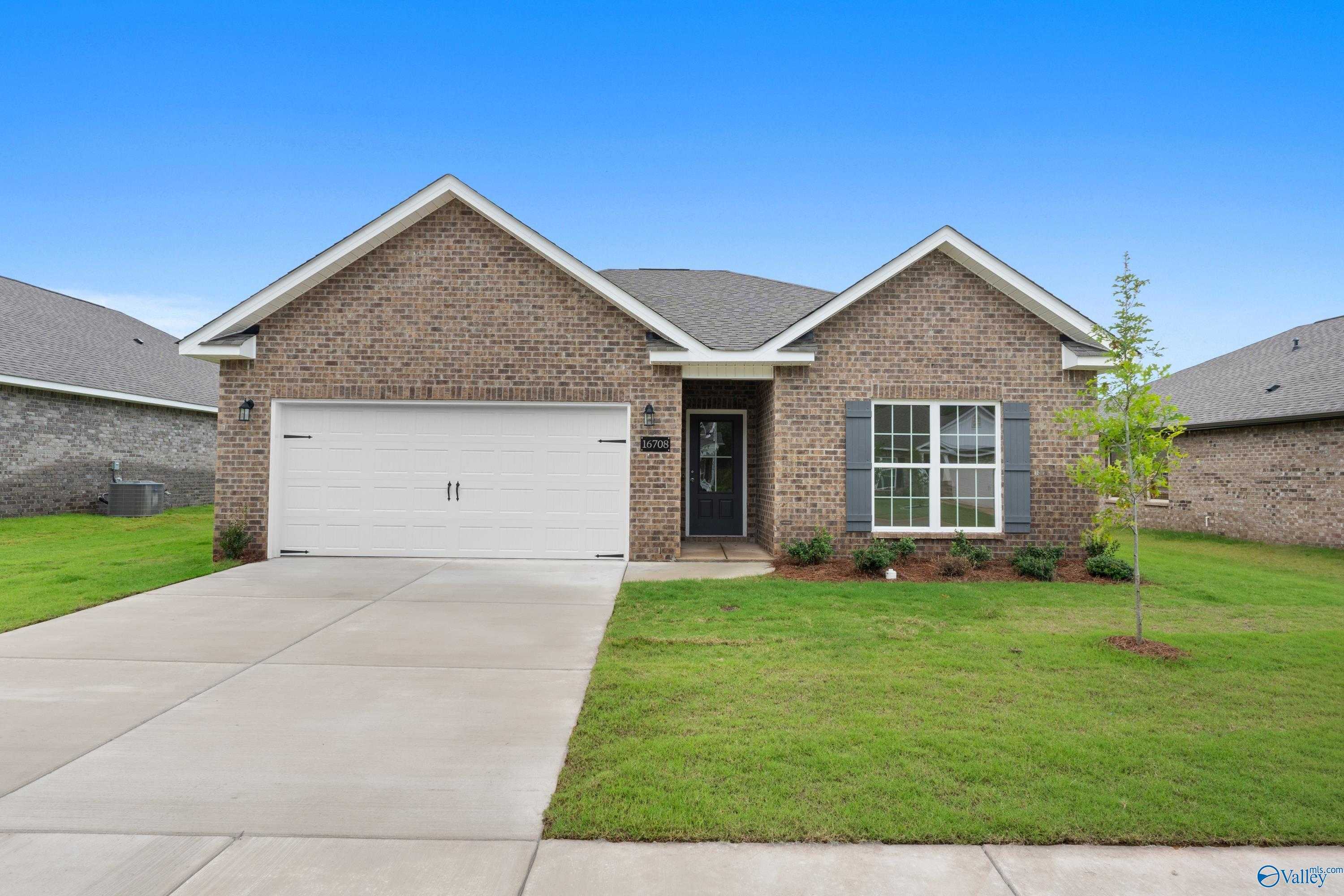 Single-story brick home with 2-car garage, driveway, and lush green lawn in Ricketts Farm, Athens, Alabama - Davidson Homes The Asheville C