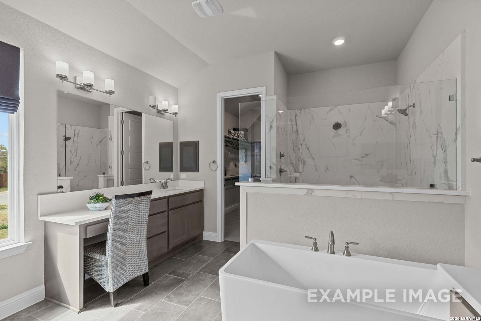 Modern master bathroom with soaking tub, glass-enclosed shower, and vanity in The Garner C floor plan, Castroville, TX.