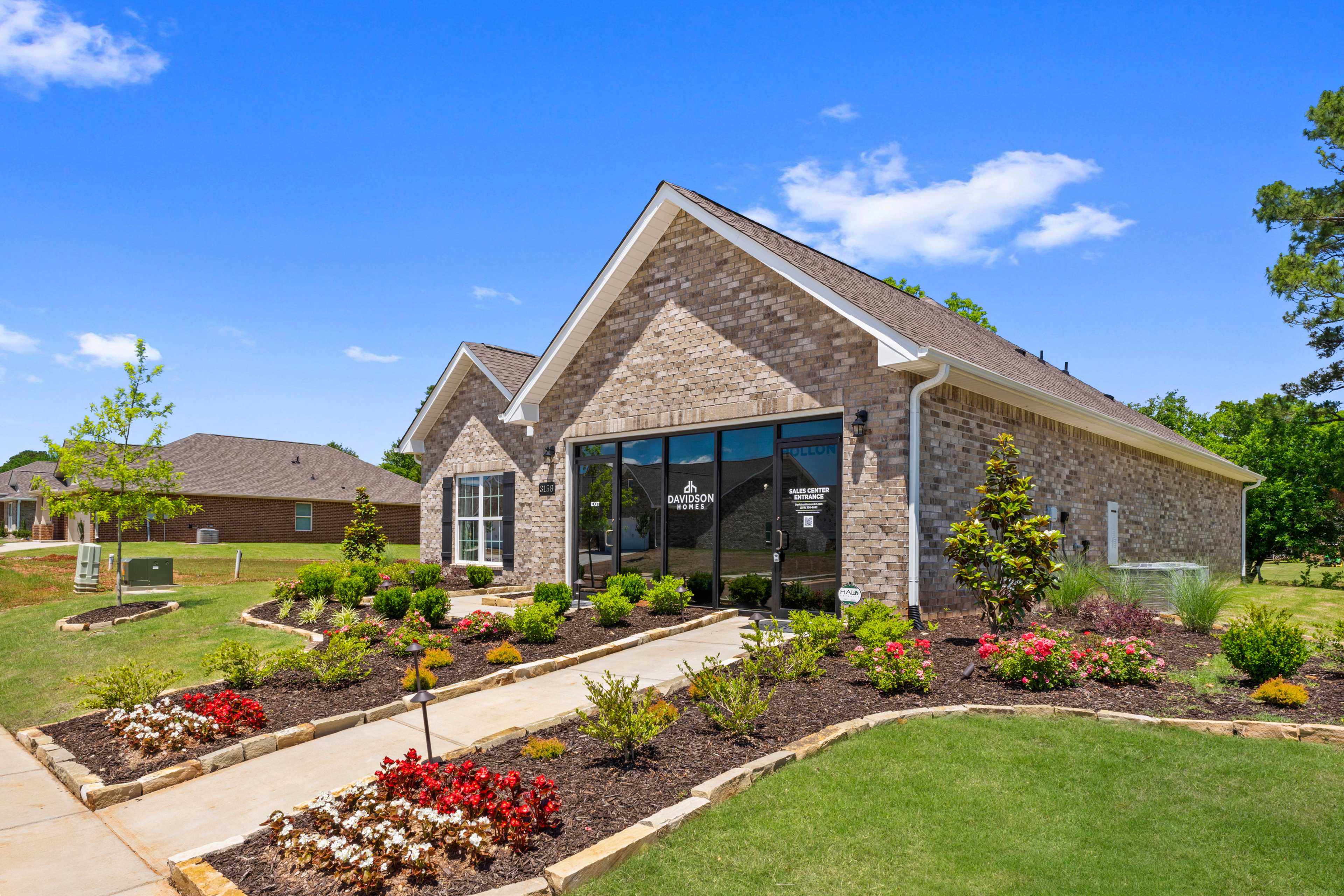 Davidson Homes sales office at Hollon Meadow in Decatur Alabama with brick exterior large windows and landscaped flower beds
