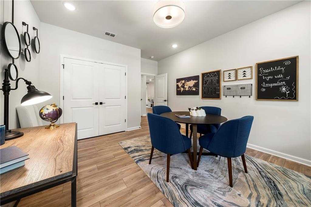 Cozy home office with wooden desk, globe, round table, blue chairs, world map, blackboard in Davidson Homes The Hickory B, Dallas, Georgia