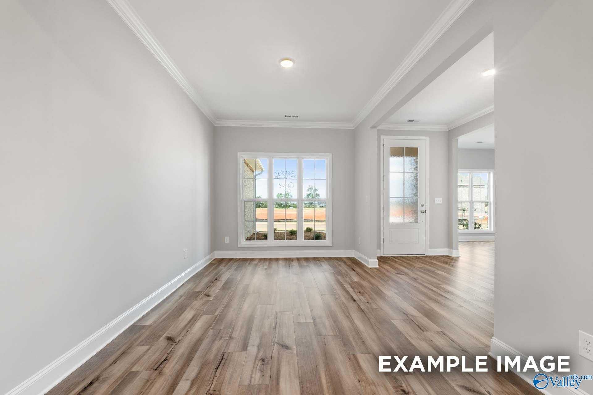 Bright entry foyer with hardwood floors, gray walls, large window overlooking greenery in The Richmond D home, Huntsville AL