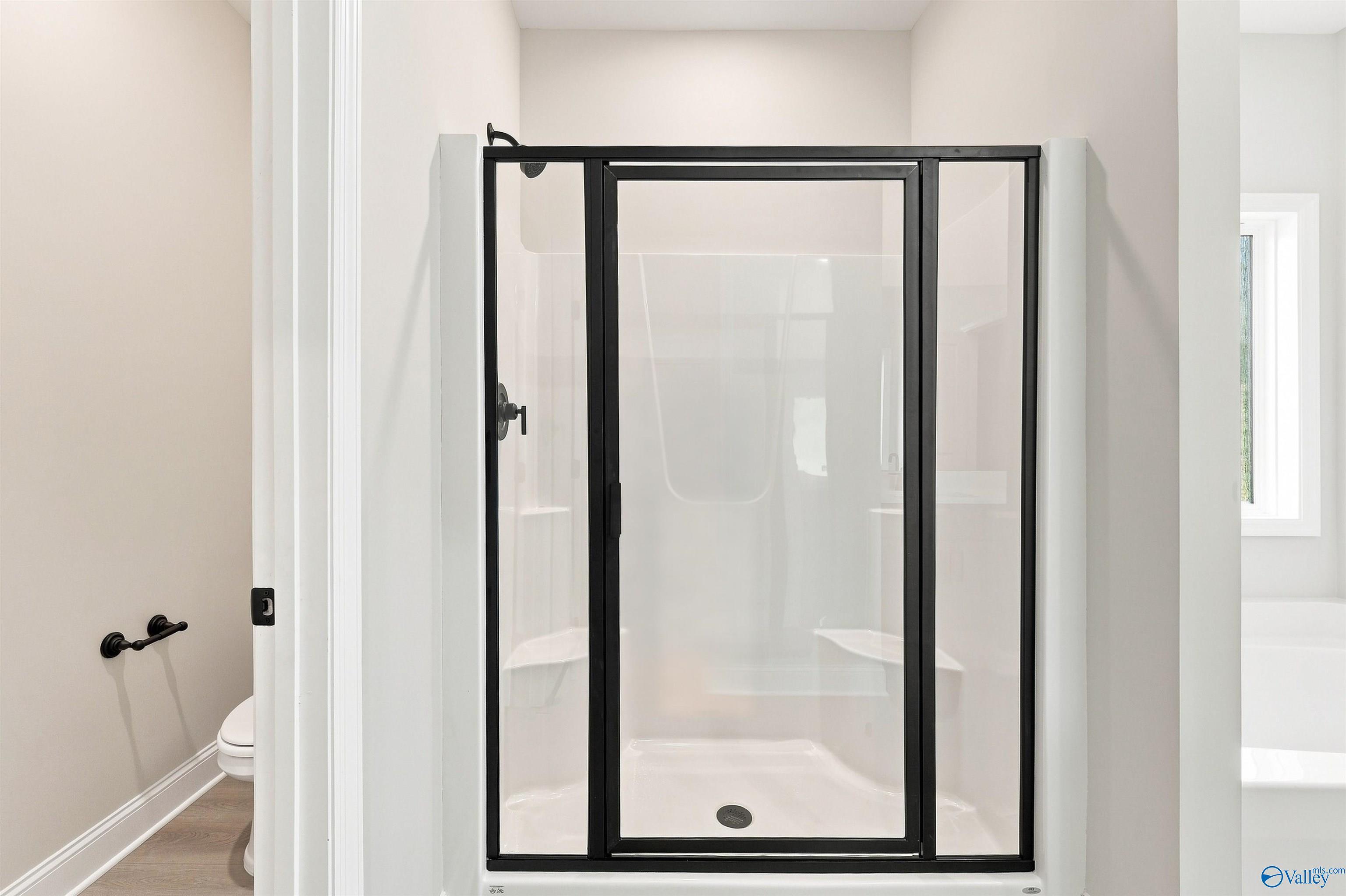 Modern walk-in shower with black frame in The Daphne floor plan at Spragins Cove, Huntsville, Alabama.
