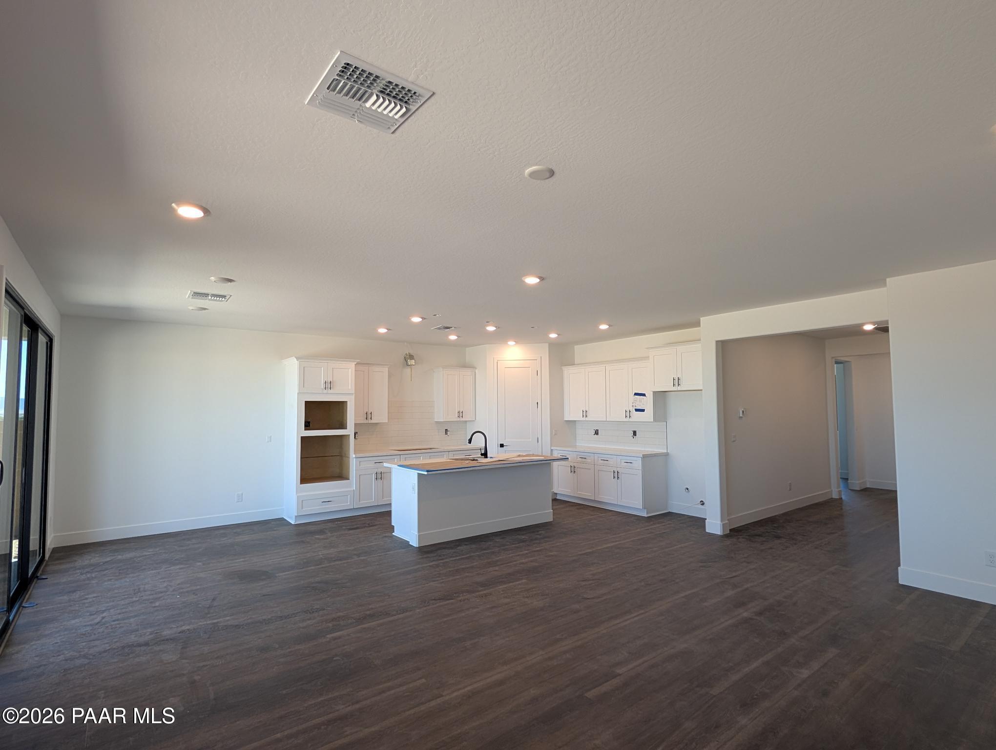 Open-concept kitchen with white cabinetry and island in The Durango II G floor plan at South Ranch, Prescott, Arizona.