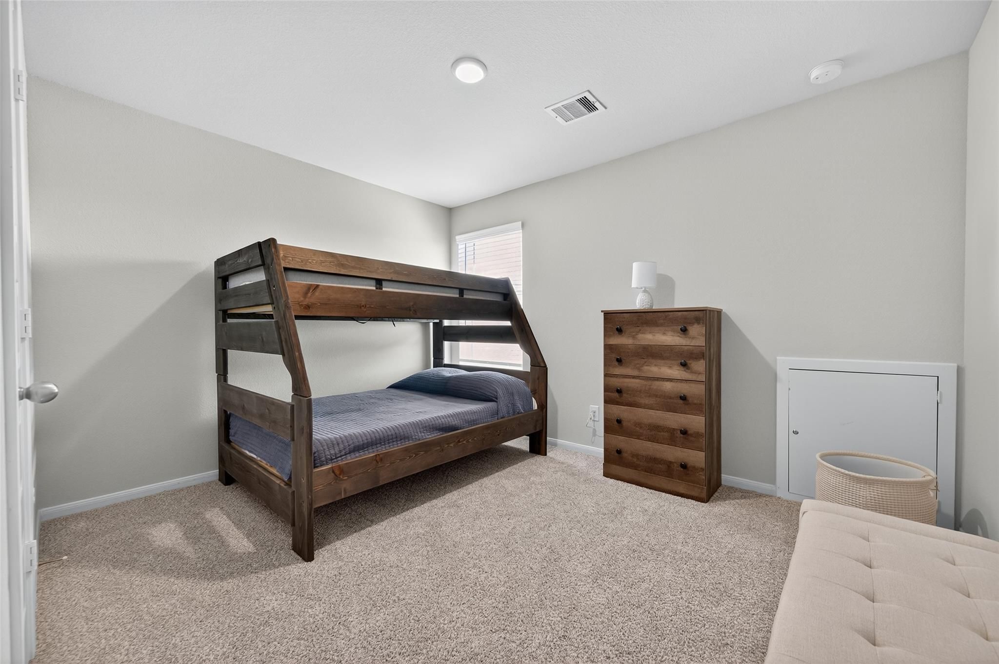 Cozy child's bedroom featuring wooden A-frame bunk beds, blue bedding, and matching dresser in 5-bedroom Davidson Homes The Brazos E, Magnolia, Texas