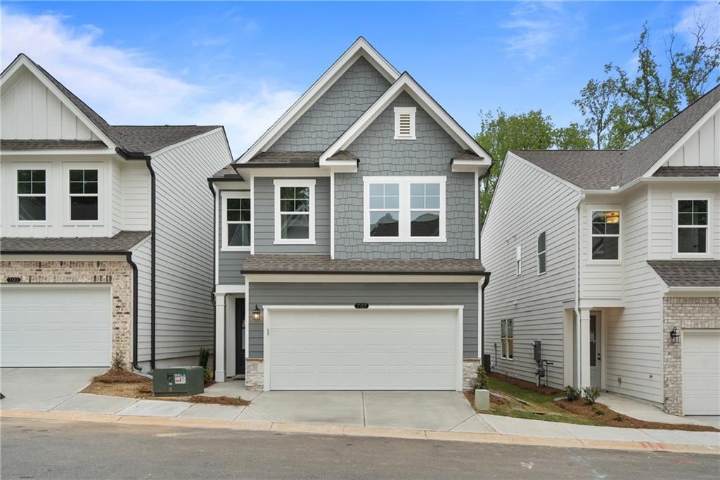 Modern gray two-story Cary B home with two-car garage and brick accents in The Village at Shallowford, Kennesaw, Georgia