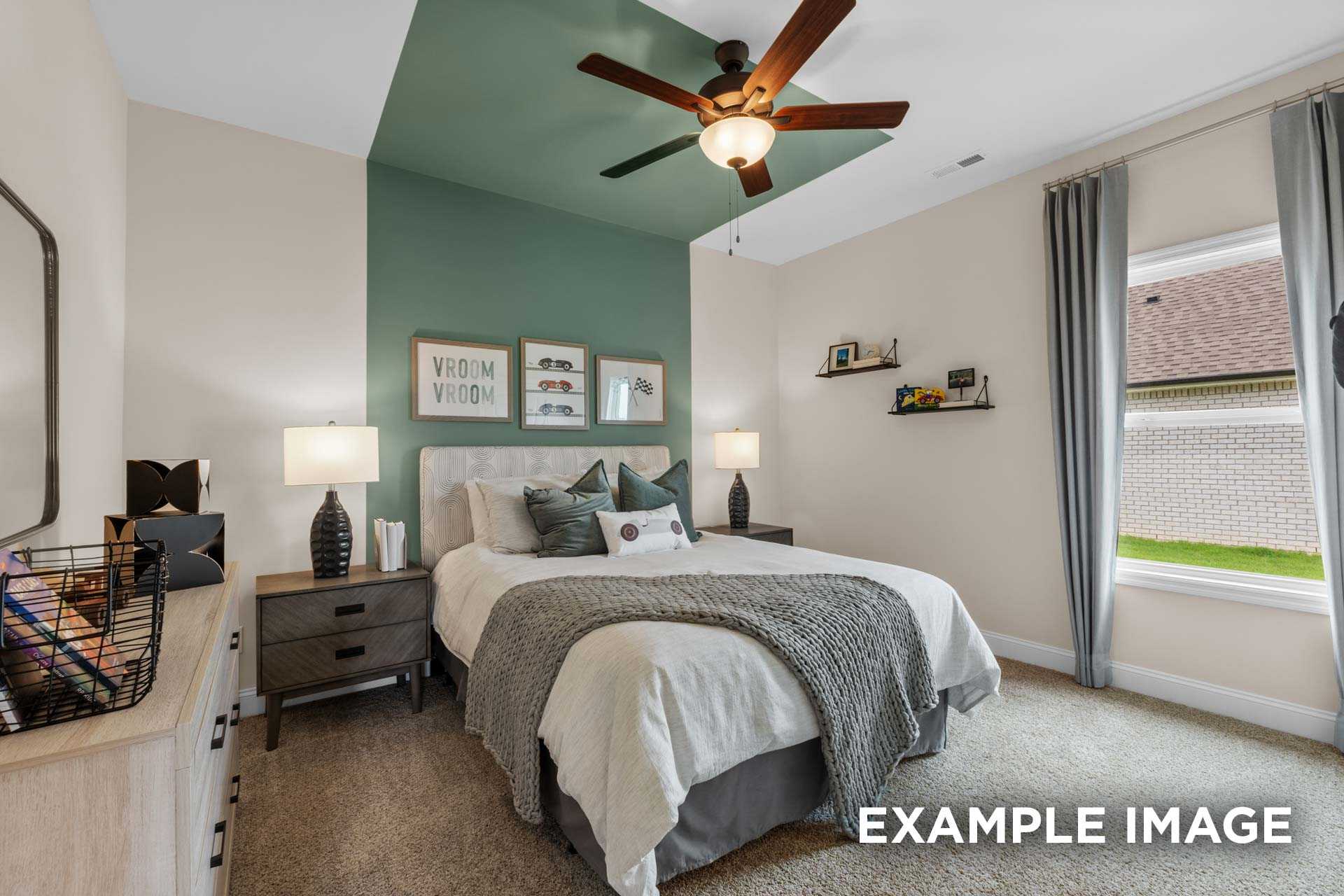 Serene master bedroom in The Laurel N with green accent wall, plush gray bed, wooden nightstands, ceiling fan, and window light