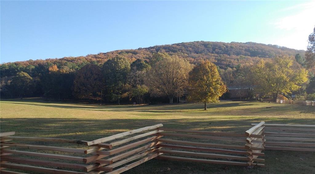 Autumn wooded hill with vibrant fall foliage, grassy meadow, and split-rail fences near The Marion A home in The Village at Shallowford, Kennesaw, Georgia
