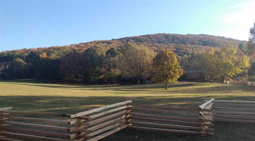 Autumn wooded hill with vibrant fall foliage, grassy meadow, and split-rail fences near The Marion A home in The Village at Shallowford, Kennesaw, Georgia